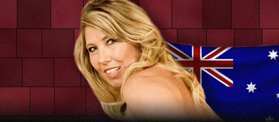 A smiling blonde woman looking back over her bare shoulder, the Australian flag behind her